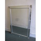 A bevelled glass wall mirror