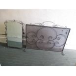 A wrought iron fire screen and wall mirror