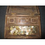 A wood chest containing vintage coins