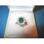 An 18ct gold oval 11 stone emerald and diamond cluster ring