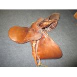 A leather pony’s saddle with brass stirrups