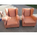 A pair of upholstered low wingback arm chairs