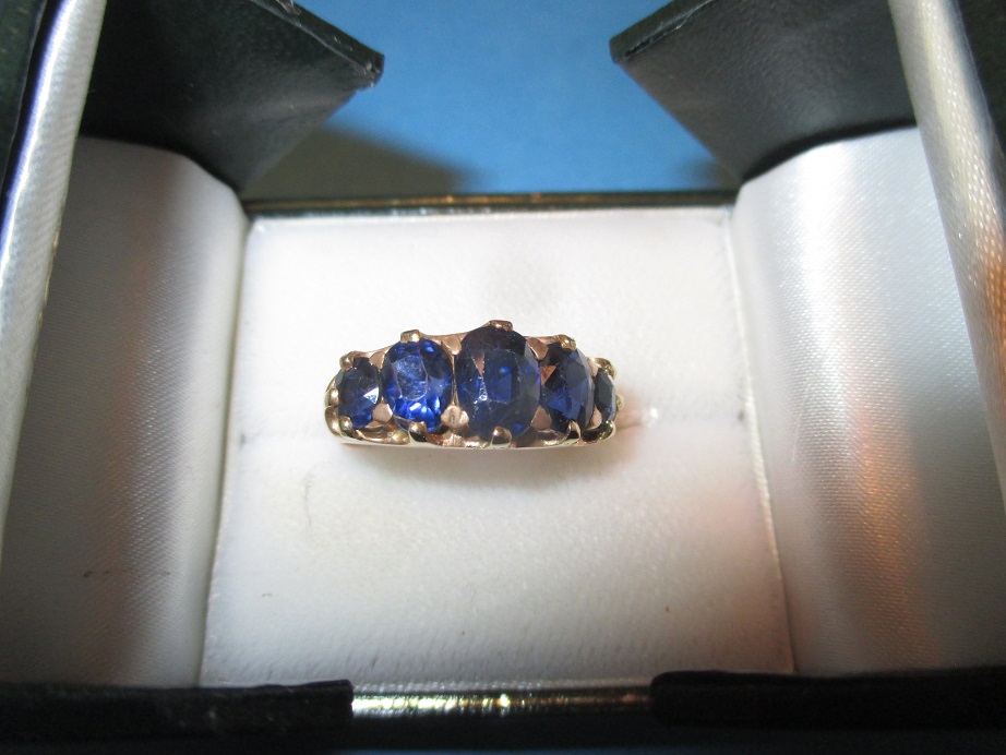 An unmarked gold 5 stone sapphire half hoop ring, approx. size M