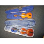 Two vintage child's violins in hard cases