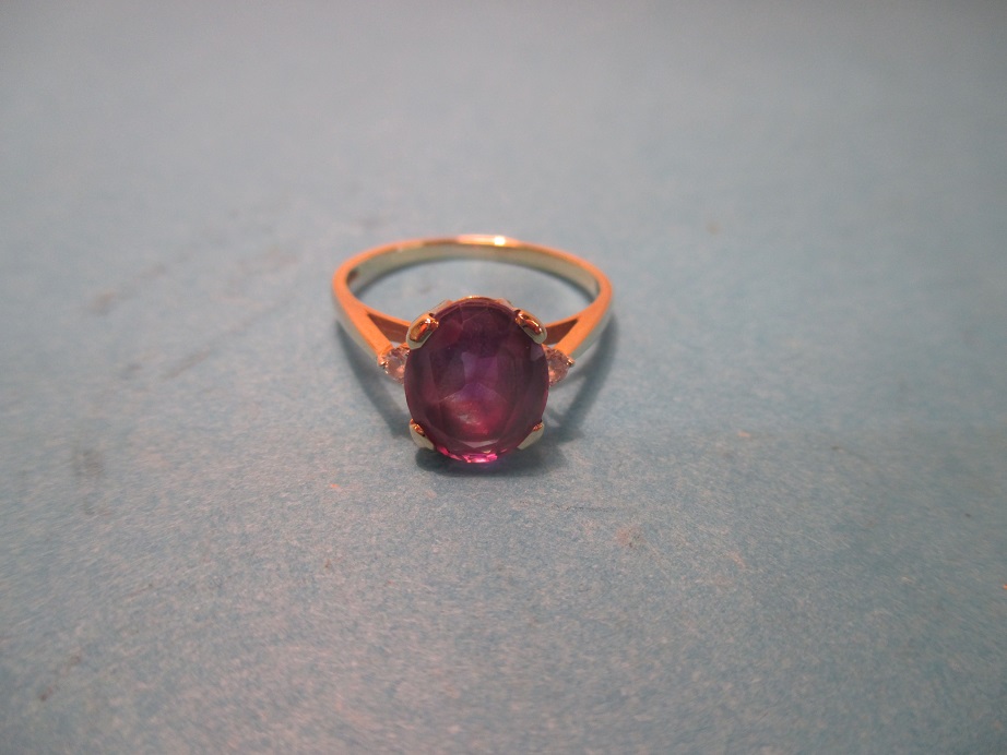 An 18ct yellow gold ring with central amethyst and diamond set shoulders, approx. ring size Q