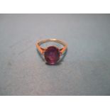 An 18ct yellow gold ring with central amethyst and diamond set shoulders, approx. ring size Q