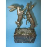 A bronze sculpture of 2 dancing hares
