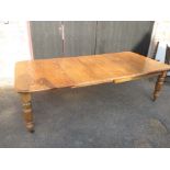 A 19th century light oak extending dining table with 3 leaves