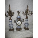 Blue Delft mantle garniture set consisting of two candelabra and clock with French movement