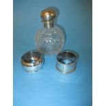 A silver topped scent bottle and 2 silver napkin rings