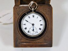 A silver pocket watch with 19thC. wooden stand