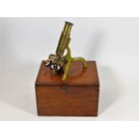 A small 19thC. brass field microscope with box & m