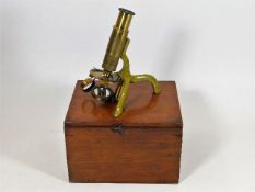 A small 19thC. brass field microscope with box & m