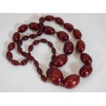 An early 20thC. set of cherry amber bakelite beads