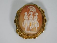 A large yellow metal cameo with three graces style