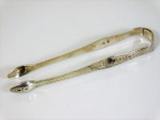 A pair of Georgian silver tongs with brightcut dec