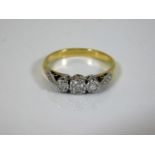 An 18ct gold diamond trilogy ring supported by eac