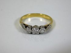An 18ct gold diamond trilogy ring supported by eac