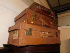Two leather covered suitcases & one other