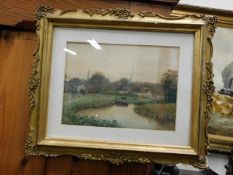 A framed watercolour of riverside scene