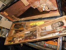 A large wooden toolbox with contents including two