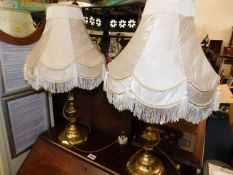 A pair of decorative brass lamps