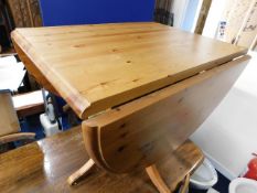 A modern pine drop leaf dining table