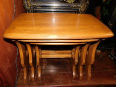 An Ercol elm nest of tables with golden dawn finis