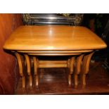 An Ercol elm nest of tables with golden dawn finis