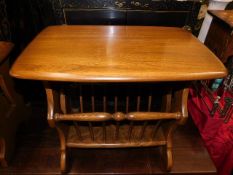 An Ercol elm magazine rack table with golden dawn
