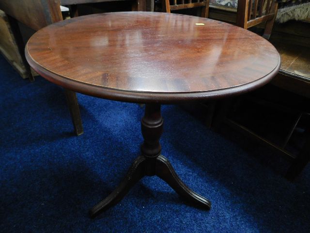 A circular mahogany pedestal table
