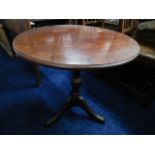 A circular mahogany pedestal table