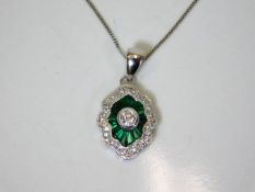 An 18ct gold pendant & chain set with emerald & di
