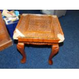 A modern low level carved table with glass top