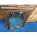 A large early 20thC. mirror with stained pine fram