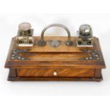 An early 20thC. oak desk inkwell set