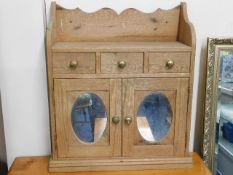 An antique pine bathroom wall cabinet