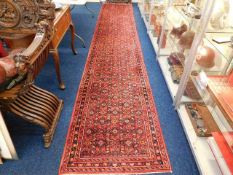 A Persian hall carpet runner measuring 198in x 34i