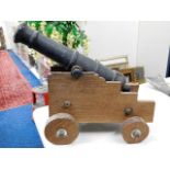 A large floor standing cannon on oak stand