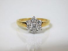 A good 18ct gold daisy ring set with seven lively
