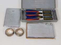Two silver napkin rings, a set of vintage darts & two chrome smokers accessories