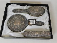 A three piece embossed silver dressing table set w