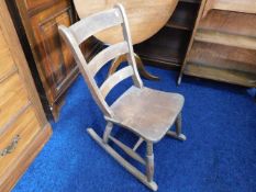 An antique childs rocking chair with elm seat