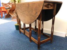 An arts & crafts style drop leaf oak dining table