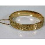 A 9ct gold bangle with engraved decor approx. 12.9