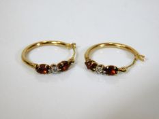 A pair of 9ct gold hoop earrings set with diamonds