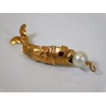 A yellow metal articulated fish pendant set with c