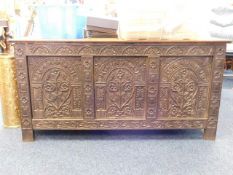 An antique carved oak coffer with later top