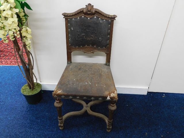 A 19thC. continental oak chair with embossed crest