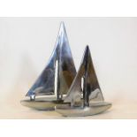 Two stylised polished aluminium yachts